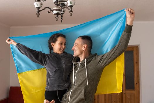 Father with daughter holding Ukrainian flag. Peace and pray for Ukraine