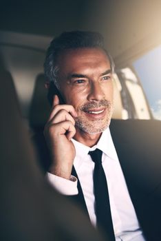 Fortune level Flying instead of driving. Shot of a mature businessman using a mobile phone while traveling in a helicopter.