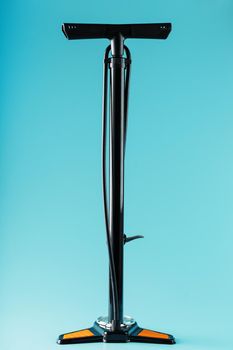 Black bicycle manual air pump for pumping wheels on a blue background