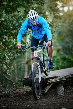 Navigating the trail with great skill. Shot of a male cyclist riding along a mountain bike trail.