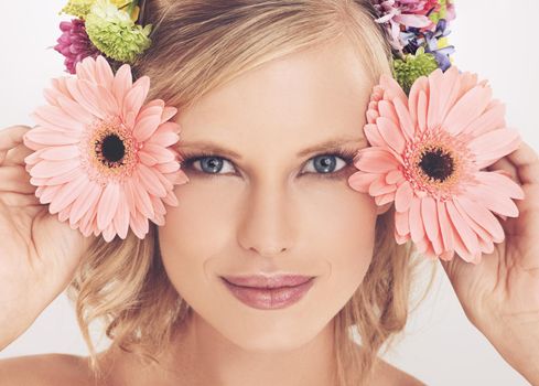 Floral beauty. A young woman with a flower arrangement in her hair smiling at the camera.