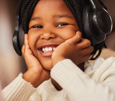 Music is the cure to all bad days. Shot of a little girl wearing headphones at home.