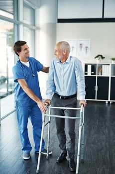 Youre made some great improvement. Shot of a male nurse assisting a senior patient with a walker.