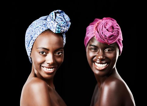 Looking stunning in their scarves. Studio portrait of two beautiful women wearing headscarves against a black background.