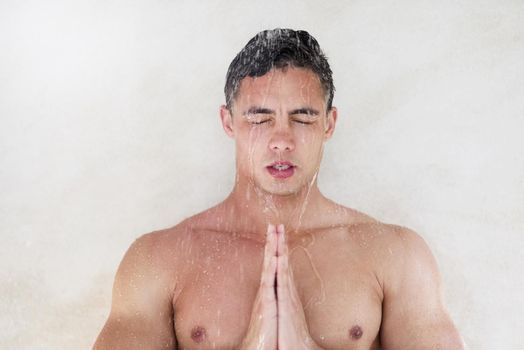 Cleanse the body, cleanse the mind. Shot of a handsome young man meditating while having a shower.