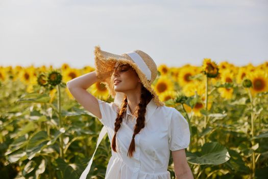 woman with pigtails In a field with blooming sunflowers countryside. High quality photo