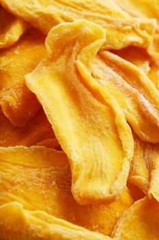 Pieces of sweet dried mango close-up as a background in full screen