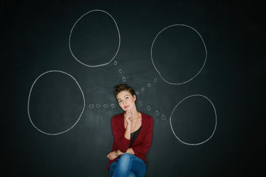 Change happens when you decide to make one. Studio shot of a young woman posing with a chalk illustration of thought bubbles against a dark background.