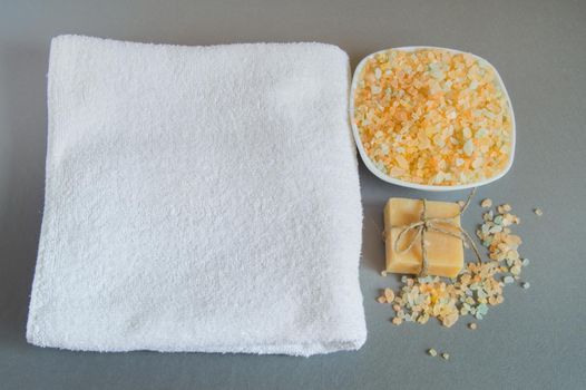 Handmade soap, a white towel, sea salt for body care