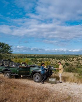 South Africa, luxury safari car during game drive, couple men and woman on safari in South Africa