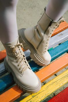 Female legs wearing white fashion boots with laces.