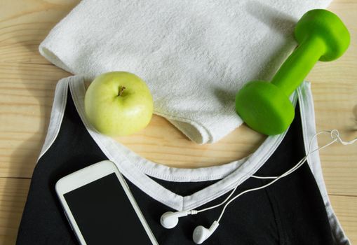 The concept of a healthy lifestyle. Apple, dumbbell, towel, t-shirt