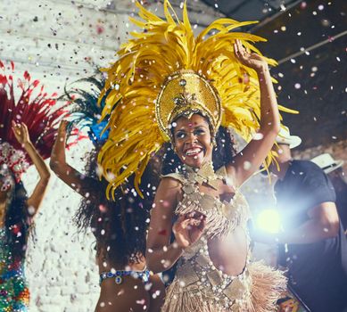 To having the time of our lives. Cropped shot of beautiful samba dancers performing in a carnival with their band.