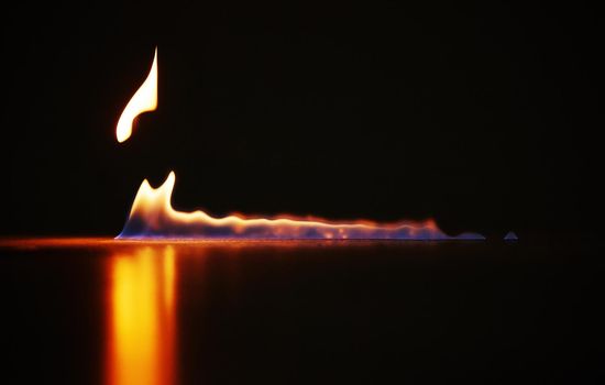 Studio shot of a small flame burning against a black background.