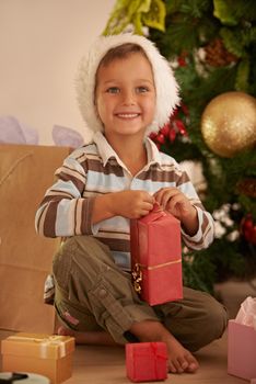 Excited to open the first gift. Shot of a young boy opening a gift on Christmas.