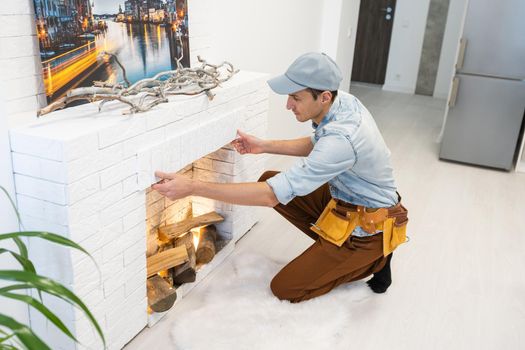 Service technician repairing a fireplace in a home