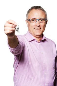They are all yours. Studio portrait of a mature man holding keys up to the camera.