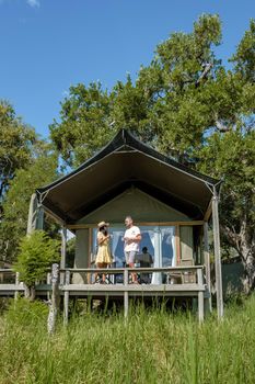couple men and woman in front of safari tent on a luxury safary,South Africa, luxury safari lodge in the bush