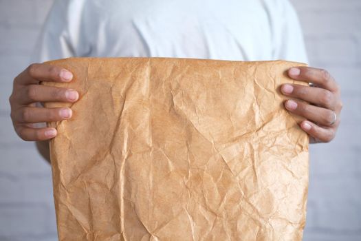 holding a a lunch paper packet close up
