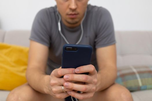 young man in headphones watching at mobile phone