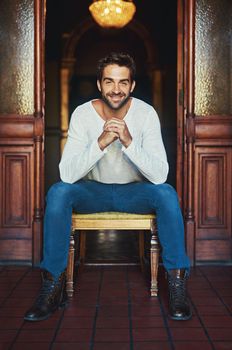 The secret to looking good is feeling good. Portrait of a handsome man dressed in casual wear posing on a chair.