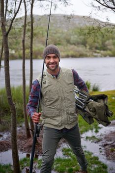 Fishing - his idea of fun. Portrait of a handsome young man enjoying his fishing trip.