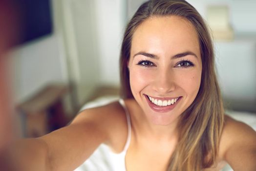 Smile Its Saturday. Shot of a young woman taking a morning selfie at home.