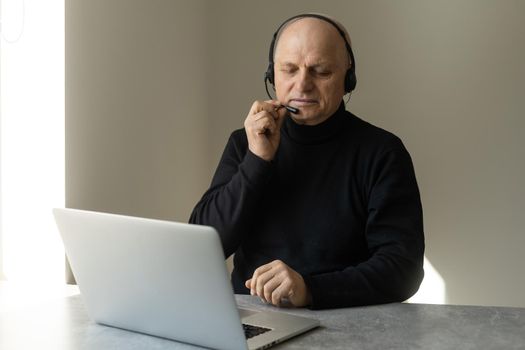 Senior man connected on laptop at home