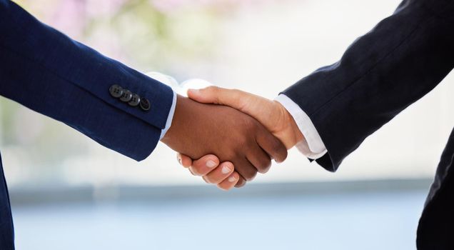 Welcome aboard partner. Shot of two unrecognisable businessmen shaking hands in a modern office.