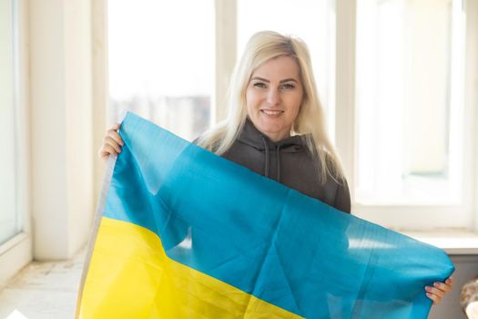 refugee woman with flag of ukraine. Patriotism, struggle, hope. War in Ukraine. Freedom for Ukraine. There is no war.