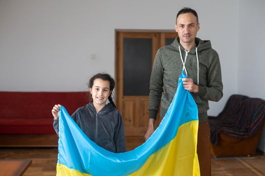Father with daughter holding Ukrainian flag. Peace and pray for Ukraine