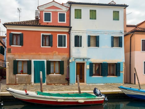 BURANO, VENICE, ITALY - Jan 29th 2019 - The colorful, painted houses on the Venetian island of Burano. Boats are moored on the canal.