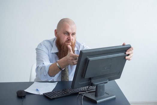 Problems for the office worker. A bald man in a white shirt sits at a desk with a computer and is stressed because of failure. A nervous breakdown.