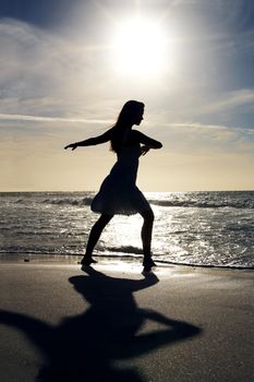 Young woman dancing on the sea shore. Portrait of a young woman dancing on the sea shore - Outdoor.
