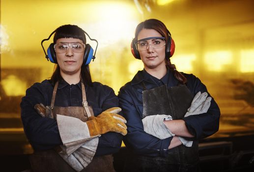 Were confident in our ability to create. Cropped portrait of two attractive young female artisans standing with their arms crossed in their workshop.