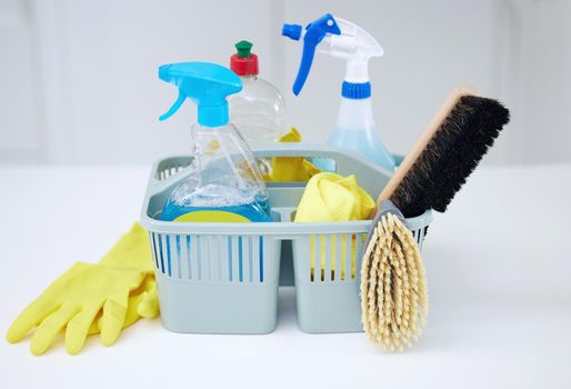 Ready for action. Shot of cleaning supplies in a basket on a table.