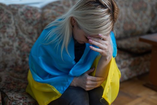 Crying sad depressed frightened emotional woman with Ukraine flag. Stop war between Russia and Ukraine. Stay with Ukraine. Pray and hope for peace and world. Copy space