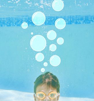 Whats on your mind. Shot of a little boy swimming underwater with bubbles above his head.