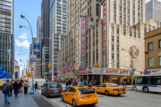 Radio City Music Hall, New York City with yellow Taxi Cabs in the forefront
