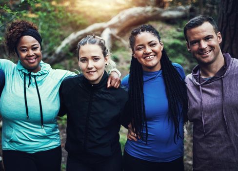 Some fresh air and great friends coming together to workout. Portrait of a group of sporty young friends standing in a row while working out in the forest.