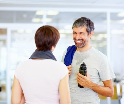 Happy conversing at fitness center. Portrait of mature man with woman after fitness exercise.