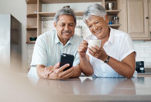 Theyve got the hang of technology. Shot of a senior couple using a phone together at home.