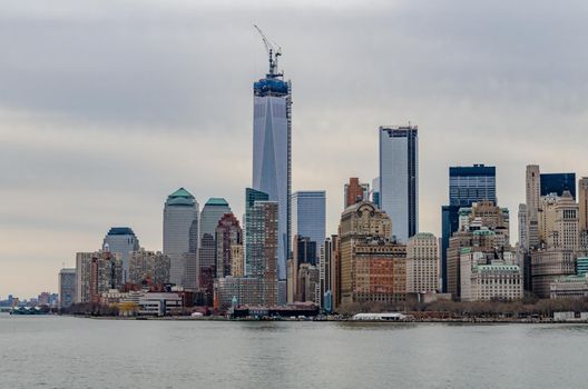 Skyline of Manhattan with One World Trade Center construction site and Hudson River in forefront