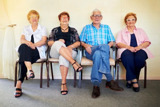 Shot of a group cheerful elderly people smiling and posing for the camera inside of a building.