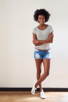 Its shorts season again. Portrait of an attractive and happy young woman wearing a striped sweater and denim shorts indoors.