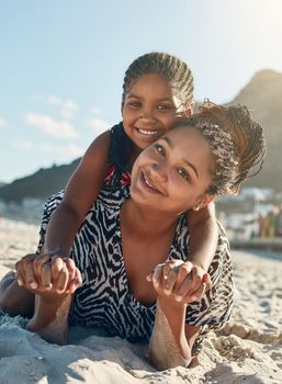 Its our girls only day. Portrait of a mother and her little daughter enjoying some quality time together at the beach.