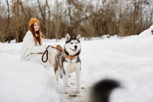 portrait of a woman outdoors in a field in winter walking with a dog Lifestyle. High quality photo