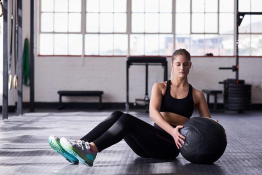 Are you looking for a great stomach toning workout. Shot of a young woman using a medicine ball in an exercise routine.
