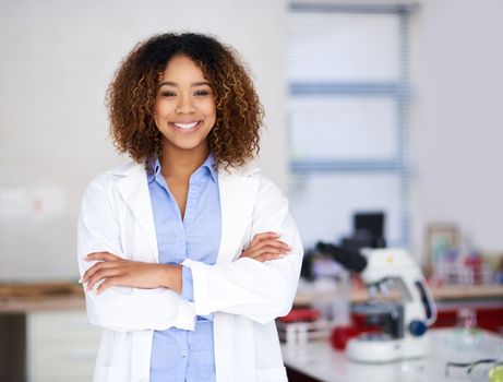 Ill find the cure. Portrait of an attractive young scientist standing with her arms folded in the lab.