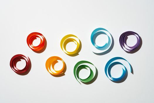 Rainbow colored paper circles on white background